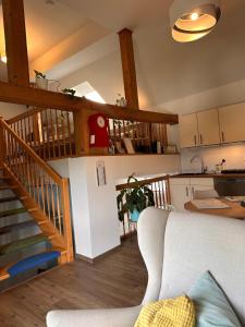 a living room with a staircase and a kitchen at Ferienwohnung Westerburg in Westerburg +20 photos