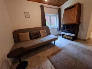 a living room with a couch and a fireplace at Cozy Cottage in Nature in Bernstein