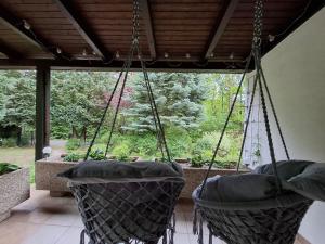 a porch with two chairs hanging from a ceiling at Cozy Cottage in Nature in Bernstein
