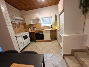 a small kitchen with white appliances and a table at Cozy Cottage in Nature in Bernstein +17 photos