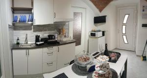 a kitchen with white cabinets and a table with food at G&G Giusy e Gabry in Viverone