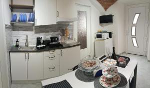 a kitchen with white cabinets and a table with bowls of food at G&G Giusy e Gabry in Viverone +9 photos