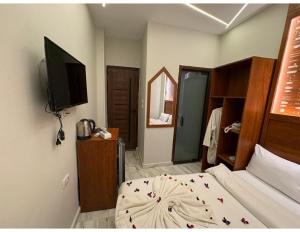 a bedroom with a bed and a flat screen tv at Hermes On The Spot Pyramids Hotel in Cairo
