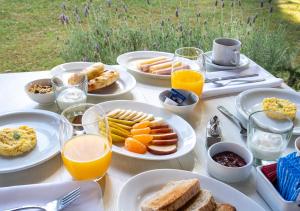 a table with plates of breakfast foods and glasses of orange juice at Postales by DOT Boutique in Colonia Las Rosas