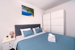 a bedroom with a blue bed and a white cabinet at Villa Olivarum in Stankovci +53 photos