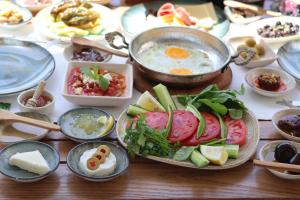a table with plates of food and a bowl of soup at My Angels Alaçatı in Alaçatı