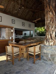 a large wooden table with two chairs and a tree at Casa Mario Alberto - Oceanfront Bungalows in Puerto Ángel