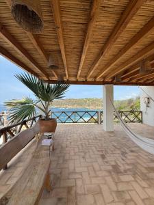 a porch with a hammock and a potted plant at Casa Mario Alberto - Oceanfront Bungalows in Puerto Ángel