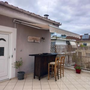 a patio with a bar and chairs on a balcony at Evi's balcony in Karditsa