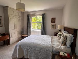 a bedroom with a white bed and a window at College Farm in Brackley