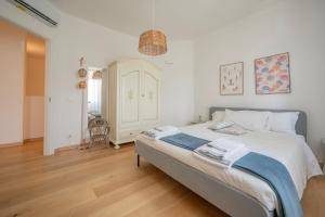 a bedroom with a bed with white walls and wooden floors at Villa Eremo Cinque Terre in Castiglione Chiavarese +58 photos