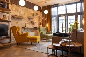 a living room with colorful chairs and a tv at Oak & Beam Atelier in Haarlem