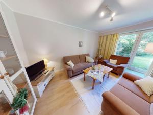 a living room with a couch and a tv at Landhaus Gerdts - 5 in Cuxhaven