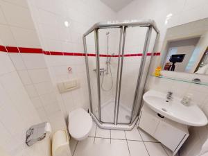 a bathroom with a shower and a toilet and a sink at Landhaus Gerdts - 5 in Cuxhaven +12 photos