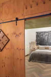 a bedroom with a bed and a large wooden door at Oak & Beam Atelier in Haarlem
