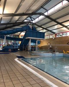 an indoor swimming pool with a water slide at Poppy in Ferndown