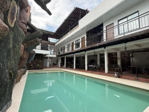 a swimming pool in front of a building at Hotel Colonial Sol y Luna in Paz de Ariporo