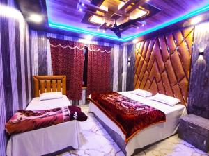 two beds in a room with purple lights at HOTEL FABULOUS KASHMIR, Dal lake in Srinagar