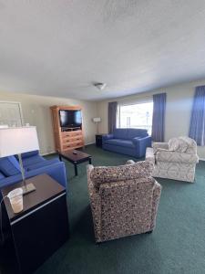 a living room with blue furniture and a flat screen tv at Shoreline Resort Condominiums in Penticton