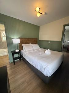 a bedroom with a large bed with a white bedspread at Shoreline Resort Condominiums in Penticton