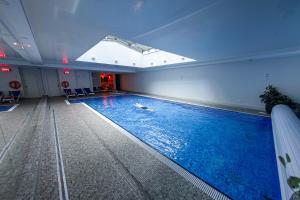 a large swimming pool in a building with a window at House of Zen - Apartament z widokiem na Motławę i Stare Miasto in Gdańsk