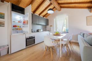 a kitchen and dining room with a white table and chairs at Villa Eremo Cinque Terre in Castiglione Chiavarese