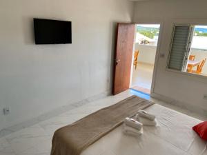 a bedroom with a bed with two towels on it at Suíte com Jacuzzi Vista de Escarpas 3 in Capitólio