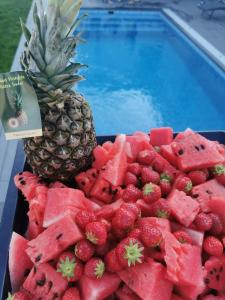 a tray of fruit next to a swimming pool at Villa med pool in Bara