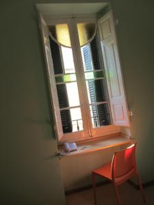 a window with a red chair in front of it at Corner Hostel in Sliema