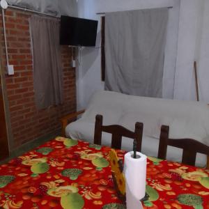 a room with two beds and a table with a candle at Hospedaje jabuticaba in El Soberbio