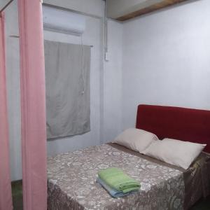 a small bedroom with a bed with a red chair at Hospedaje jabuticaba in El Soberbio