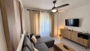 a living room with a couch and a flat screen tv at San Miguel Centro in Torremolinos