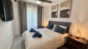 a bedroom with a bed with blue pillows on it at San Miguel Centro in Torremolinos