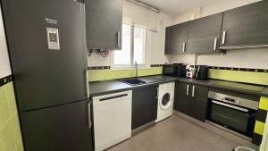a kitchen with black and white cabinets and a dishwasher at San Miguel Centro in Torremolinos