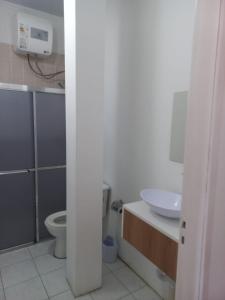 a bathroom with a toilet and a sink at Hotel Status in Jaguarão