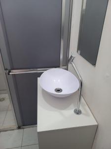 a white sink sitting on a counter in a bathroom at Hotel Status in Jaguarão