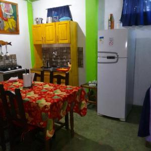 a kitchen with a table and a white refrigerator at Hospedaje jabuticaba in El Soberbio