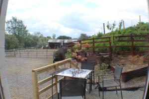 a table and chairs on a patio with a fence at Grove Stables in Kirk Leavington