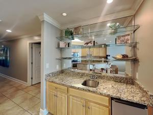 a kitchen with a sink and shelves at The Oasis Orange Beach 2110 in Orange Beach