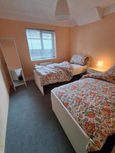 a bedroom with three beds and a window at Grove Stables in Kirk Leavington