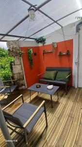 a patio with a couch and a table on a deck at Ma Maison Vigneronne in Loches
