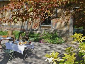 a table with food on it in a yard at B&B du Pré-Boulay in Fleury-la-Forêt