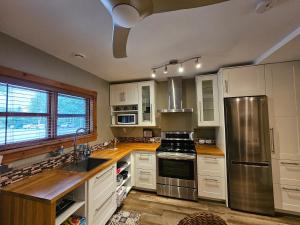 a kitchen with white cabinets and stainless steel appliances at For-Rest Inn and Spa in Bathurst