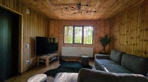 a living room with a couch and a flat screen tv at Secret Sanctuary in Brad