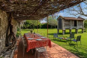 a table and chairs under a pergola in a garden at Villa Baños in Caldelas