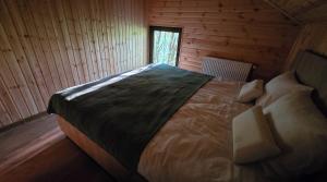 a bedroom with a large bed in a wooden cabin at Secret Sanctuary in Brad