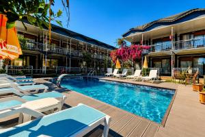 a swimming pool with lounge chairs and a hotel at Fii Suites in Kumluca +18 photos