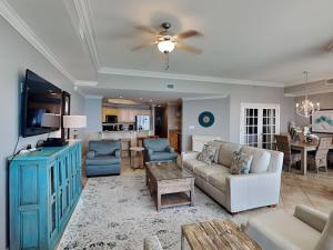 a living room with a couch and a tv at The Oasis Orange Beach 2110 in Orange Beach