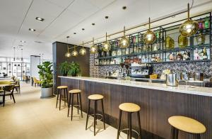 a bar in a restaurant with stools at Sercotel Madrid Aeropuerto in Madrid