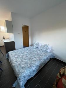 a bedroom with a bed with a blue comforter at sunny Podaca in Podaca